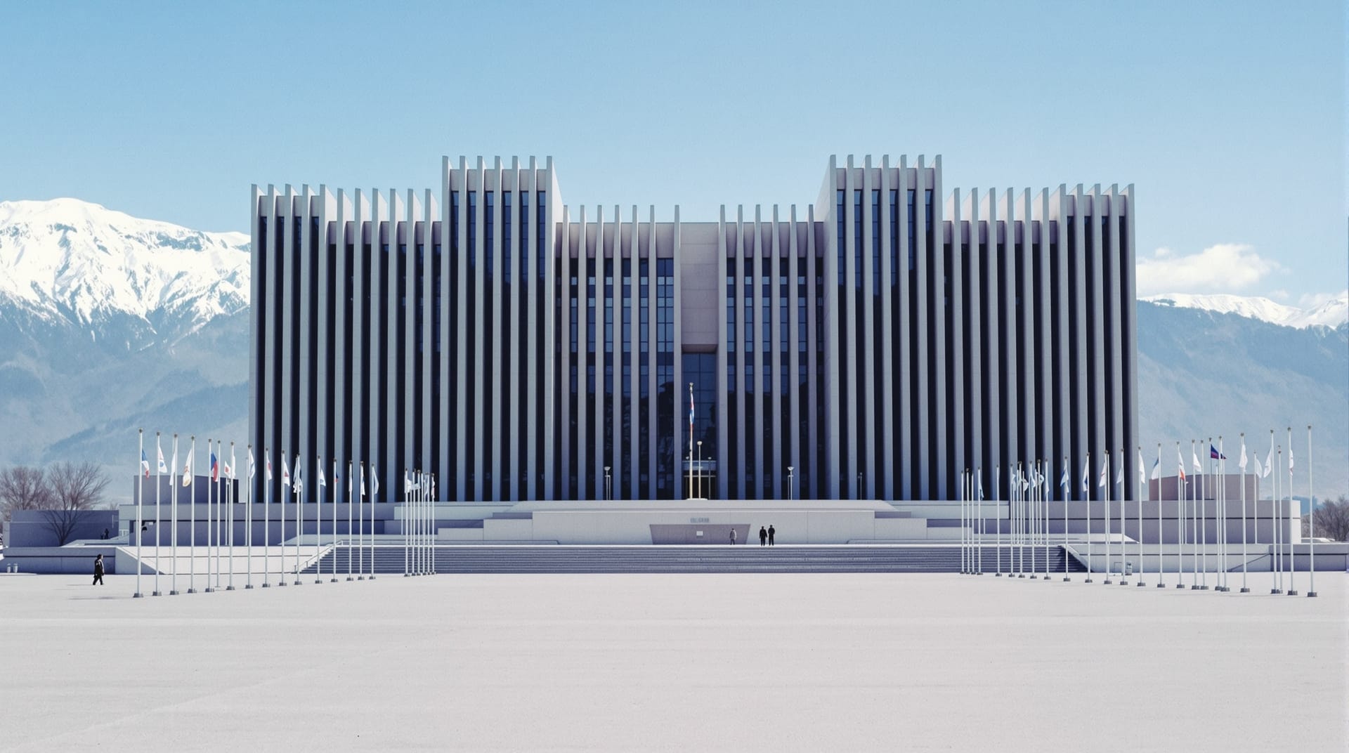 Soviet-modernist concert hall and empty plaza with mountains behind